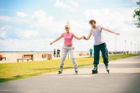Active young people friends rollerskating outdoor. Stock Photos