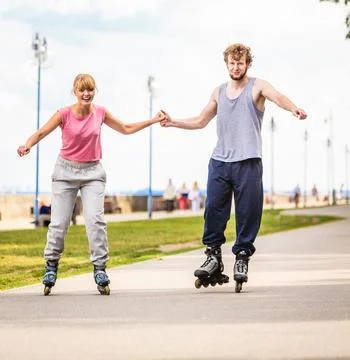 Active young people friends rollerskating outdoor. Stock Photos