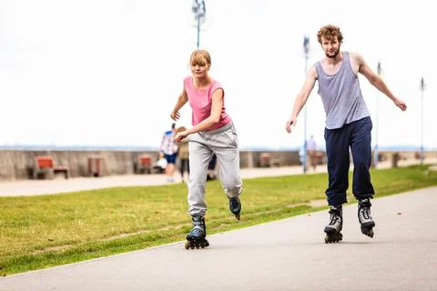 Active young people friends rollerskating outdoor. Stock Photos