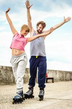 Active young people friends rollerskating outdoor. Stock Photos