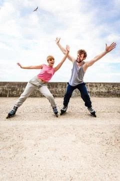 Active young people friends rollerskating outdoor. Stock Photos