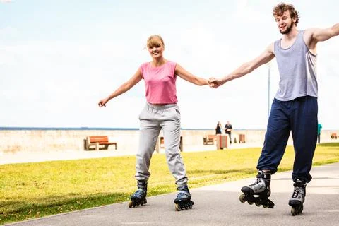 Active young people friends rollerskating outdoor. Stock Photos