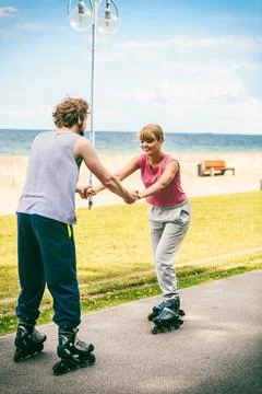 Active young people friends rollerskating outdoor. Stock Photos
