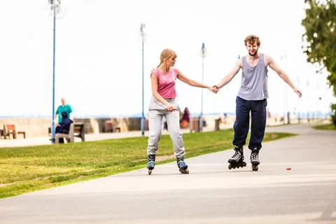 Active young people friends rollerskating outdoor. Stock Photos