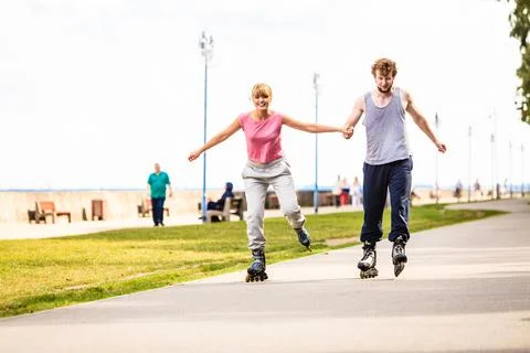 Active young people friends rollerskating outdoor. Stock Photos