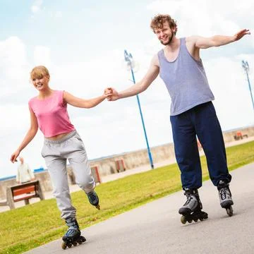 Active young people friends rollerskating outdoor. Stock Photos