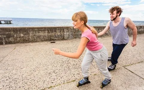 Active young people friends rollerskating outdoor. Stock Photos