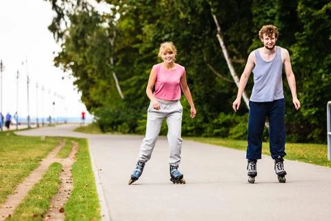 Active young people friends rollerskating outdoor. Stock Photos