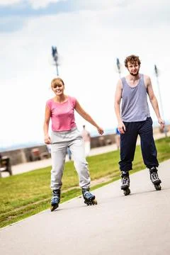 Active young people friends rollerskating outdoor. Stock Photos