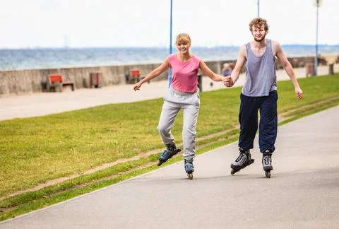Active young people friends rollerskating outdoor. Stock Photos
