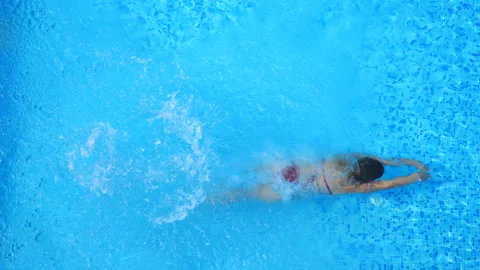 Active young woman diving in pool and splashing water. Lady relaxing on resort Stock Footage 122367455