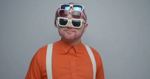 Actively dancing hipster man in orange shirt with pink hair, beard and three Stock Footage 88041528