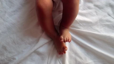 Actively moving baby's legs on bed Stock Footage 201113842