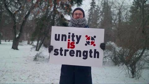 An Activist is Carrying a Placard Unity is Strength for people to get together Stock Footage 158239935