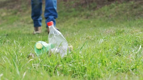 Activist picking up plastic bottles into blue plastic bag Stock Footage 106371687