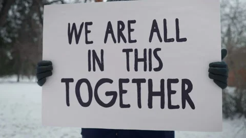 An Activist is Protesting with a huge Placard We Are All In This Together Stock Footage 158279701