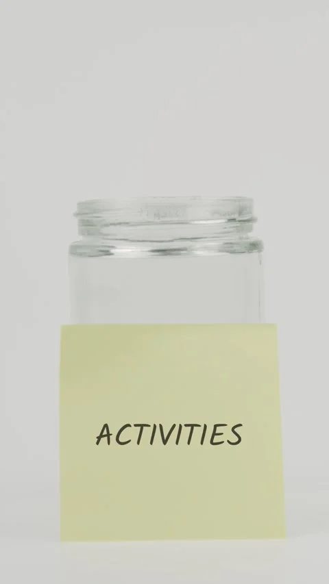 Activities text or word on yellow sticky note attached to glass jar Stock Footage 311675510