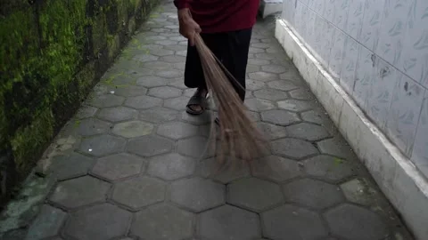 Activities of women sweeping using a broom stick on the porch of the house Stock Footage 145958531