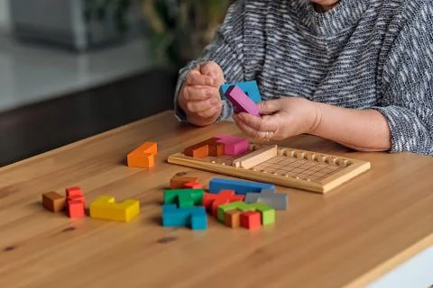 Activity can improve brain function. Elderly woman sitting at table and sorting Stock Photos