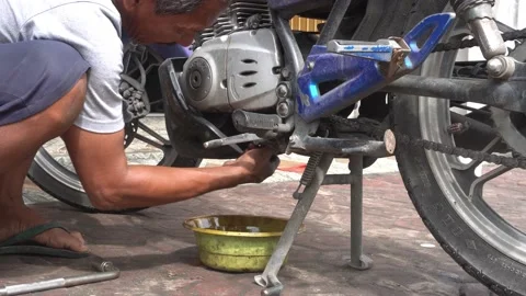Activity of changing motorcycle engine oil in a motorcycle repair shop Video stock 232470870