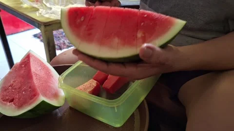 The activity of a person's hand cutting a watermelon using a knife Stock Footage 260369504