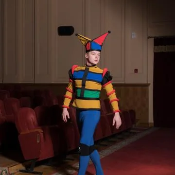 Actor dressed jester's costume in interior of old theater. Stock Photos