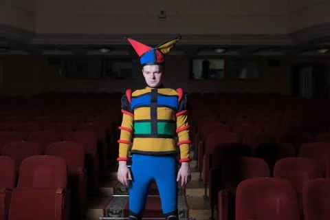 Actor dressed jester's costume in interior of old theater. Stock Photos