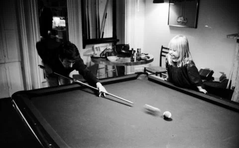 Actor Dustin Hoffman playing pool while his step daughter Karina Hoffman is stan Stock Photos