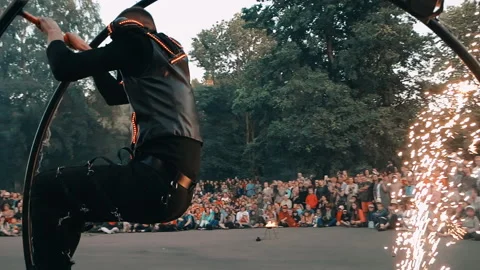 Actor of fire show performs trick with the wheel, rolling inside a metal wheel. Stock Footage 160804806
