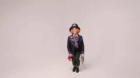 An actor in a hatter costume, he jumps and smiles. At white studio Видео 99005290