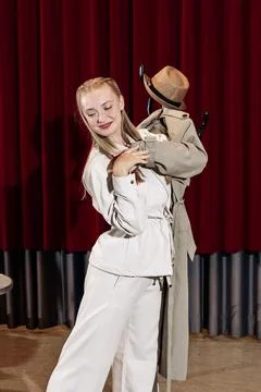 An actor performs on the theatre stage with his coat on a hanger Stock Photos
