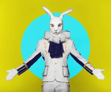 Actor posing in white rabbit suit on color yellow blue background.Studio shot Stock Photos