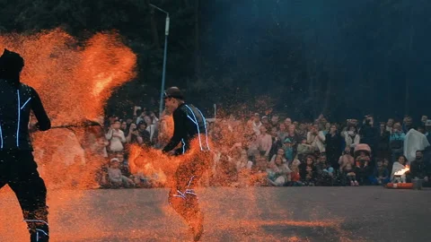 Actors of the fire show perform a trick with hot coals, sparks fly in the wind. Stock Footage 160759499