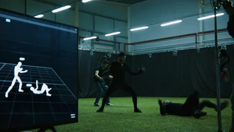 Actors in motion capture suits performing some fight moves as a game characters Stock Footage 166023386