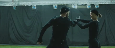 Actors in motion capture suits performing some fight moves as game characters Stock Footage 166098746