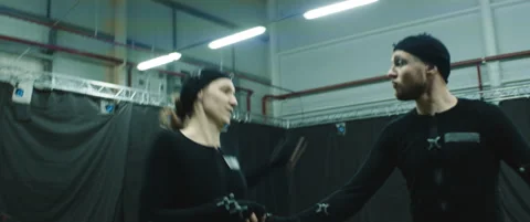 Actors in motion capture suits performing some fight moves as game characters Stock Footage 166099299