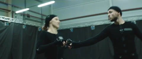 Actors in motion capture suits performing some fight moves as game characters Stock Footage 166099962