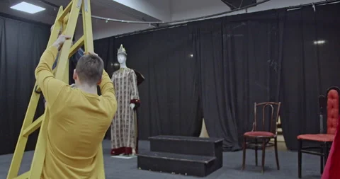 Actors Preparing the Stage for a Play: Setting Up the Scene with a Ladder Stock Footage 312073031