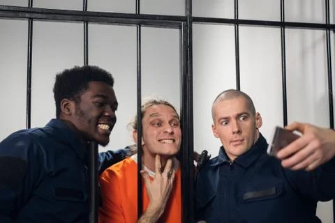 Actors on the set of a movie about prison make a funny selfie in a prison cell Stock Photos