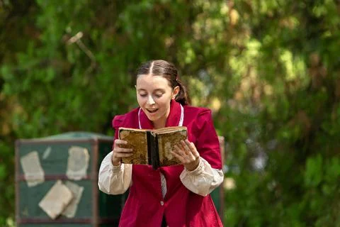 Actress reciting her lines while reading a script on stage during a rehearsal 库存照片