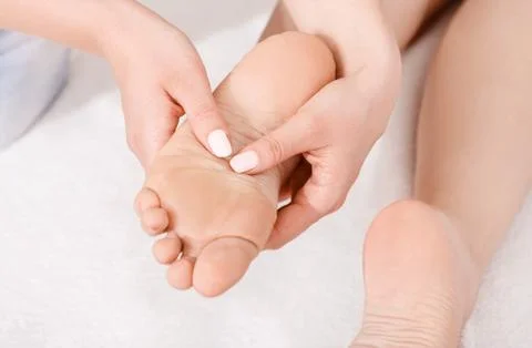 Acupressure of foot. Professional doing massage on white background Stock Photos