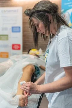 Acupuncture practitioner performing treatment on an elderly woman Stock Photos