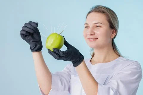 Acupuncture Training Concept Using Needles Inserted in Green Apple Studio Stock Photos