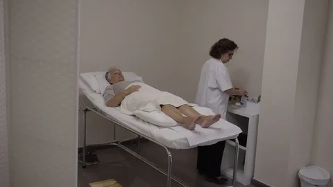 Acupuncturist manipulates needles inserted to a patient Stock Footage 99516063