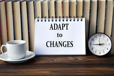 ADAPT to CHANGES - words on white notebook on background of books, clock and  Stock Photos