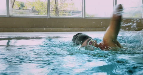 Adaptive amputee professional swimmer front crawl swimming in indoor pool Stock Footage 146137255