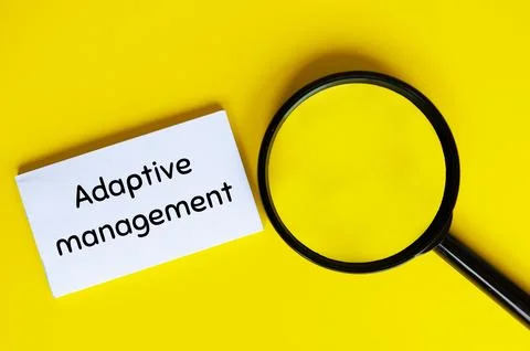 Adaptive management text on white notepad with magnifying glass. Business a.. Stock Photos