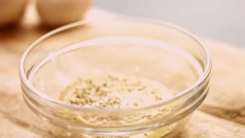 Add black pepper and minced garlic to the mustard. 4k cinematography video Stock Footage 156445466