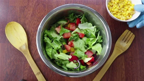 Add corn to the vegetables fresh salad in metal bowl top view Stock Footage 122560835