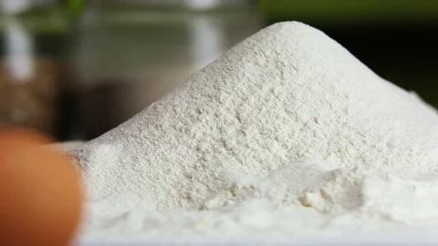 Add the egg to the flour, closeup Stock Footage 73848354